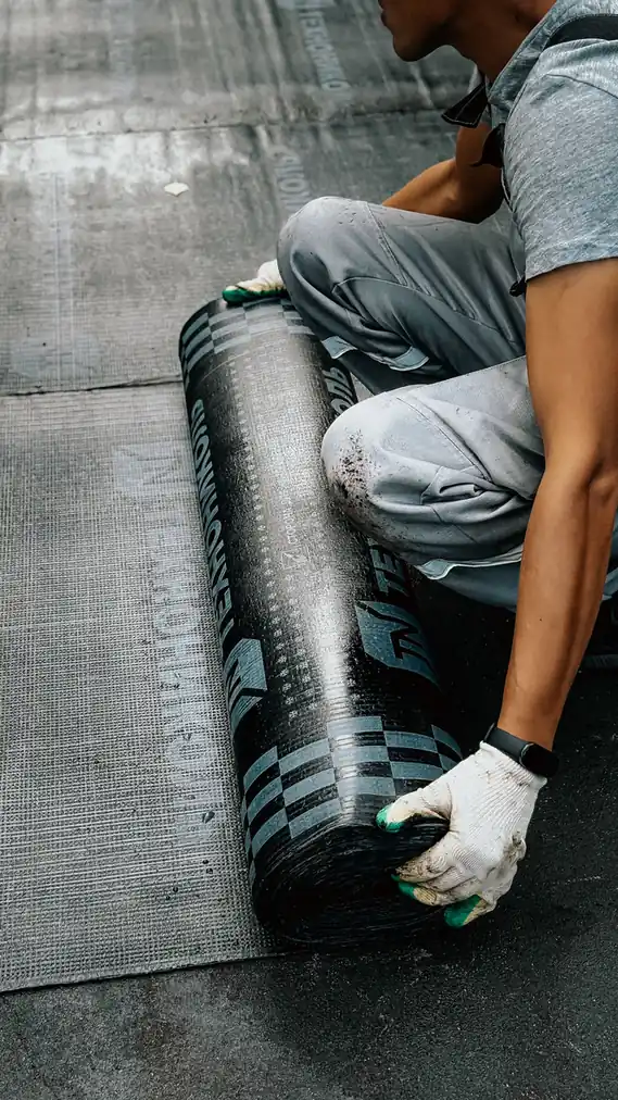 Déroulage d'un rouleau de membrane d'étanchéité sur un support plat