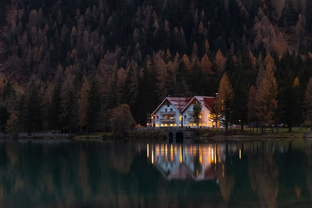 Chalet au bord d'un lac de montagne à la tombée du jour