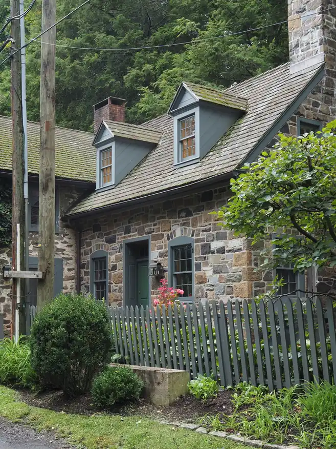 Maison de pierre à lucarnes couverte de bardeaux de bois