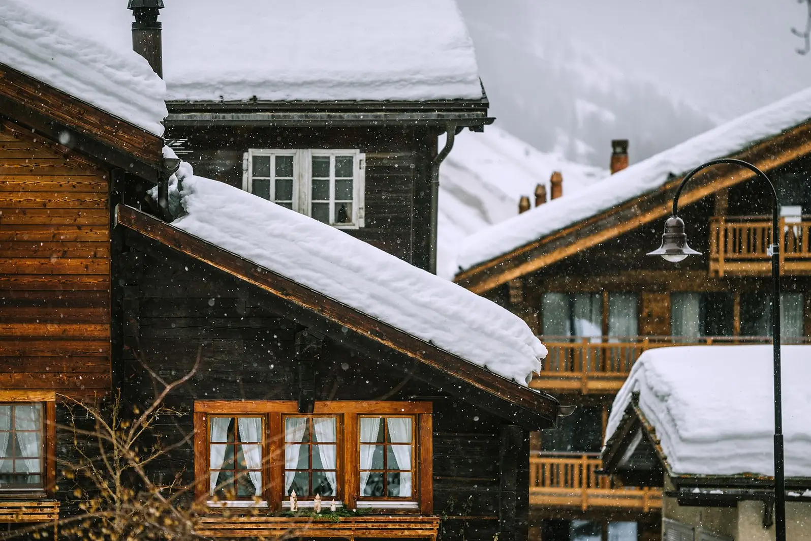 Chalets de bois sous une épaisse couche de neige pendant une chute de neige