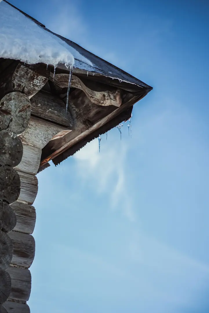 Débord de toiture en bois vu en contre-plongée sur un ciel bleu