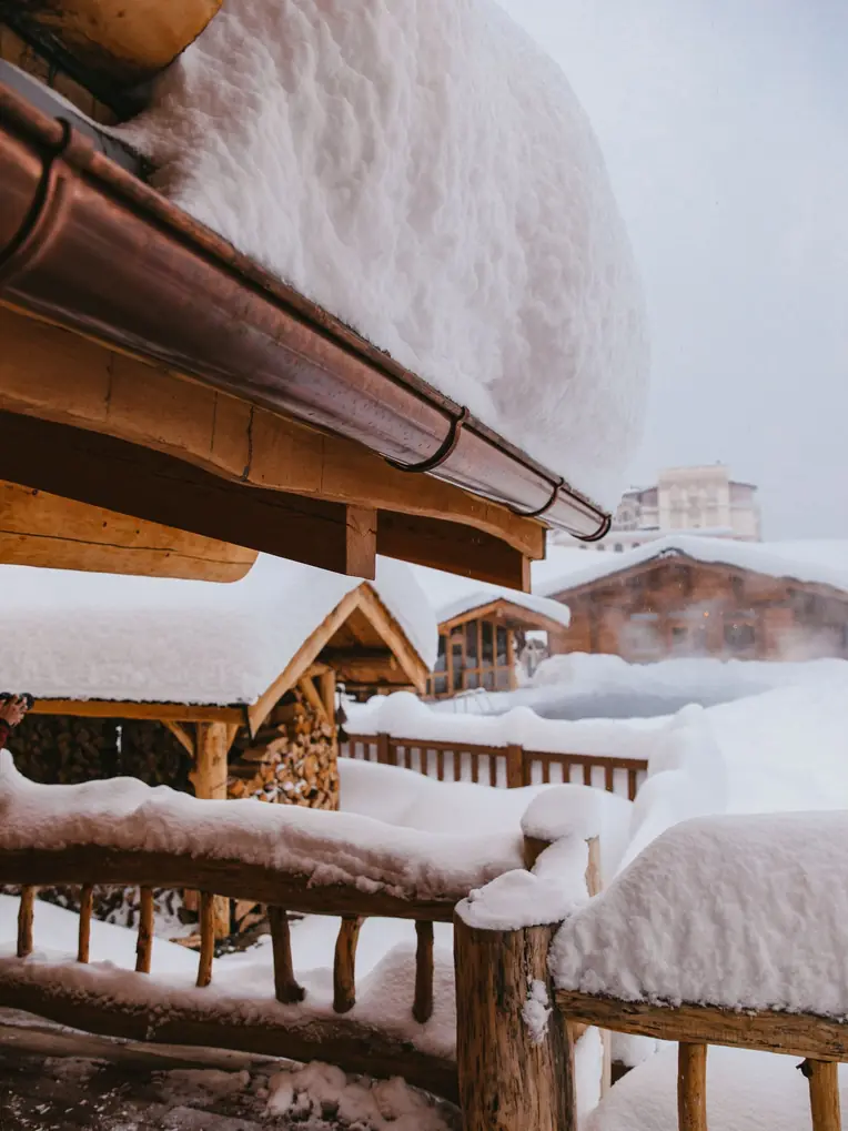 Gouttière de chalet chargée de neige tassée en hiver