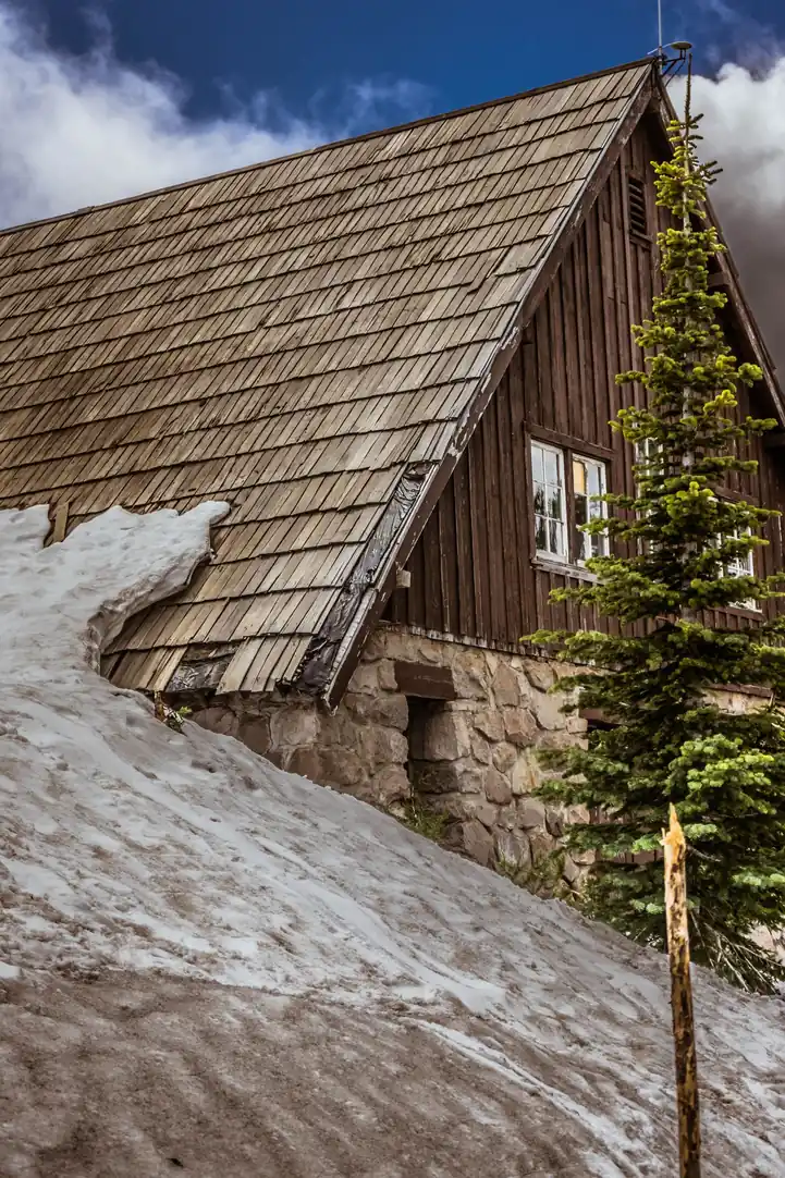 Toiture en bardeaux de bois d'un chalet, neige au sol