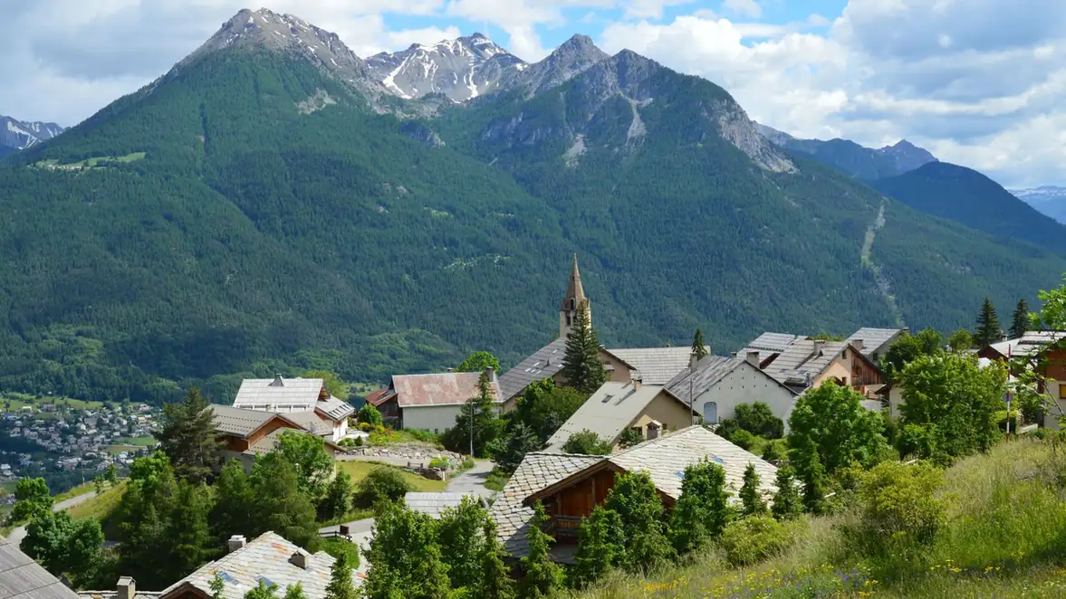 Village de fond de vallée entouré de versants boisés