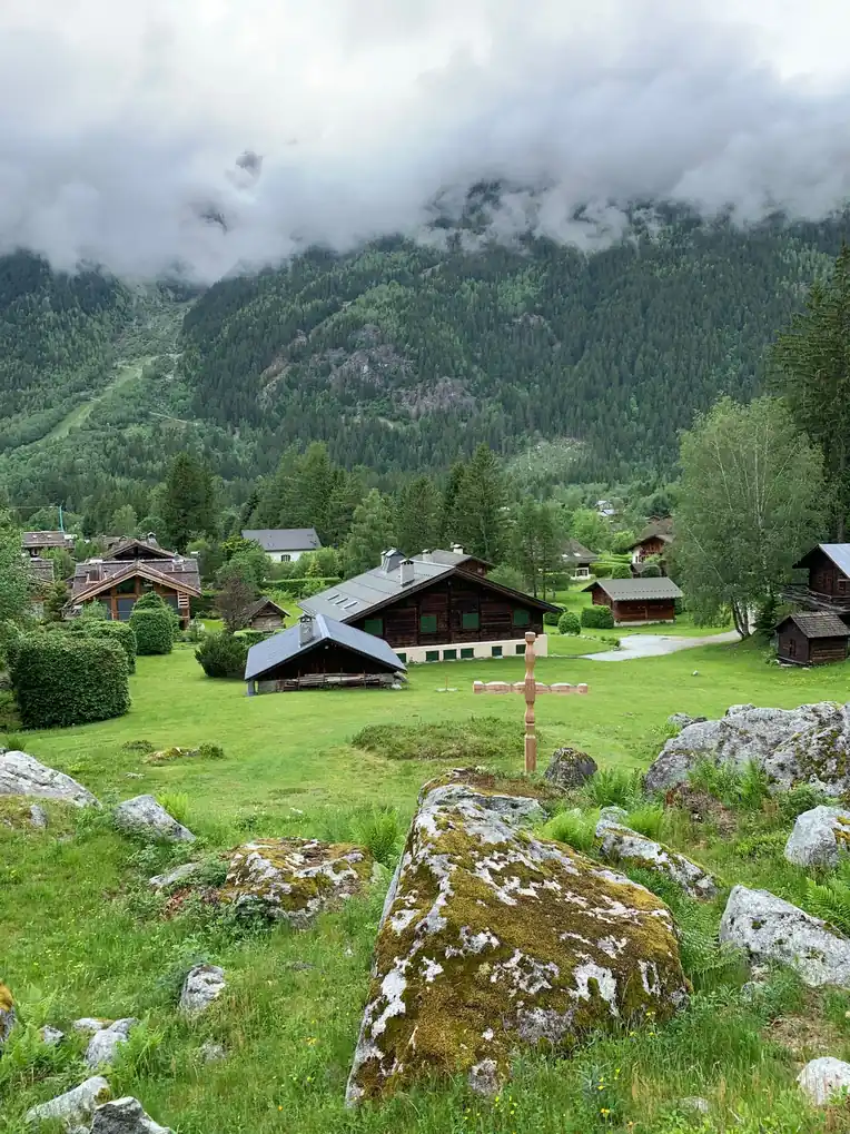 Chalets dispersés dans une prairie d'altitude sous un ciel bas