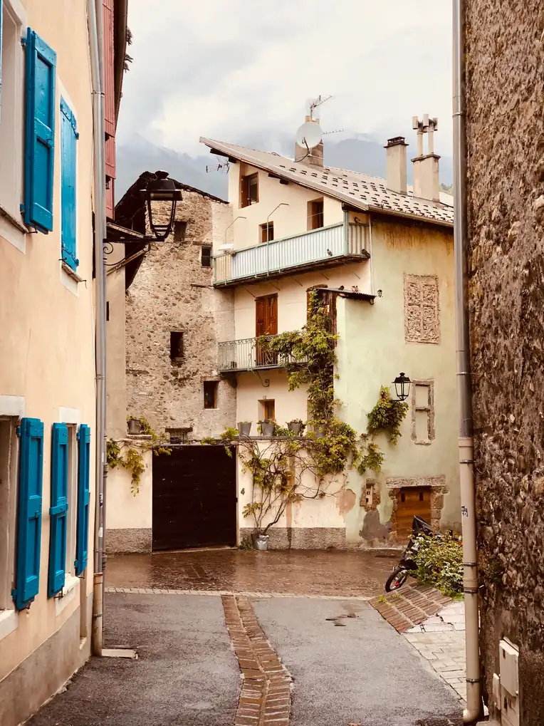 Ruelle étroite d'un village de montagne aux volets bleus